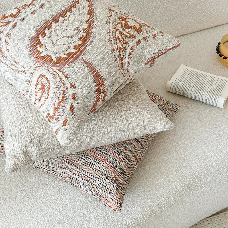 American-style jacquard woven throw pillow cover with a paisley pattern in amber colours on a sofa.