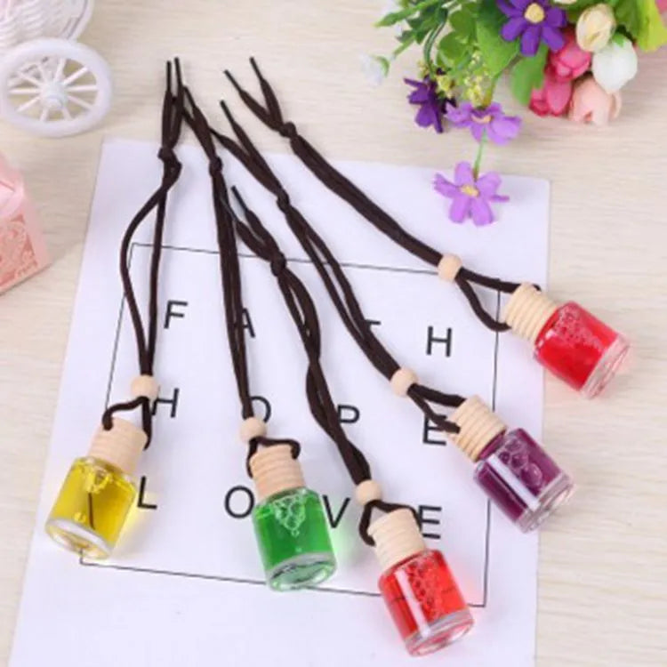 Car air freshener glass bottle hanging ornament showing scent options: Lavender, Lemon, Apple, Strawberry, Ocean, Floral.