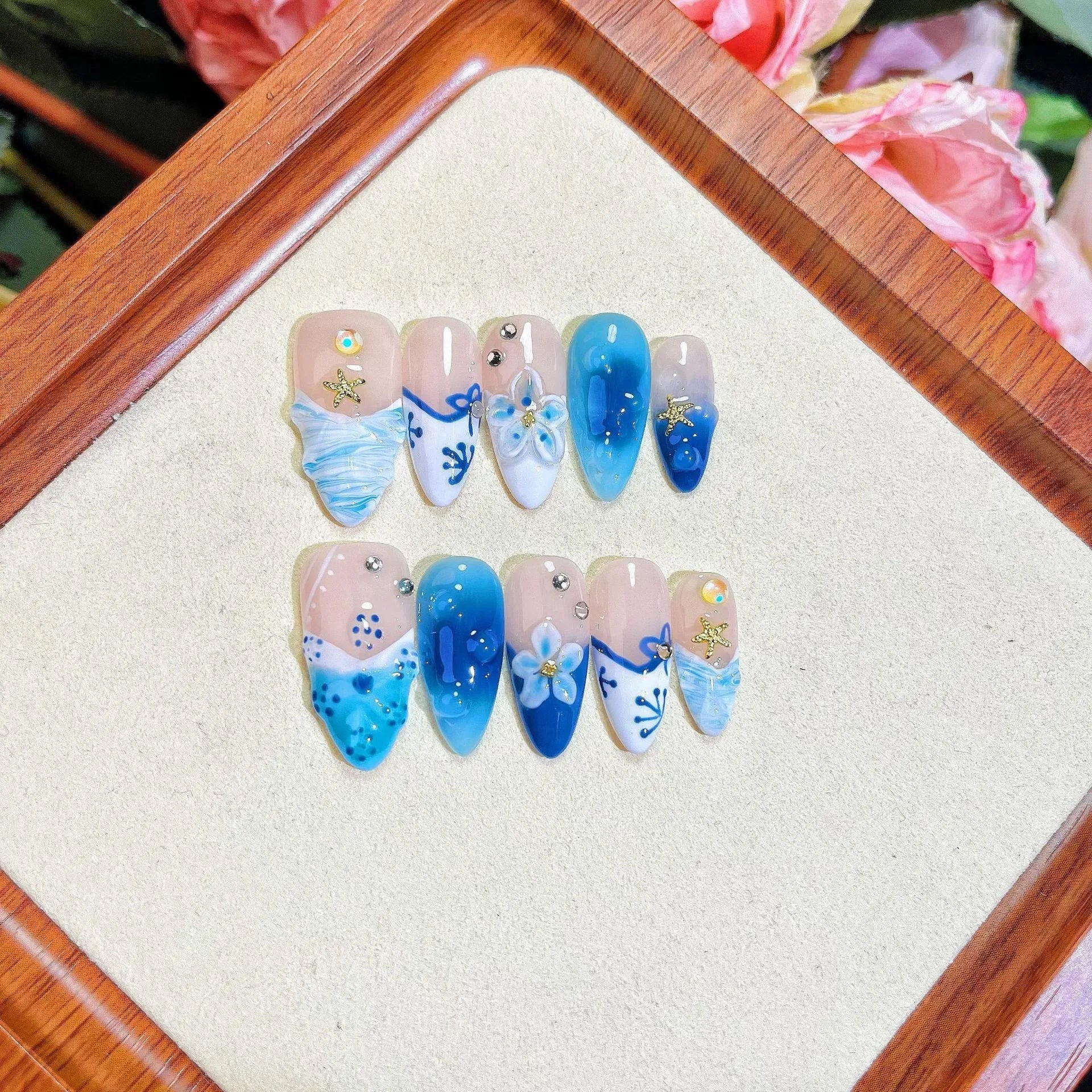 Blue hand-painted carved fake nails set with floral designs in sizes XS S M L
