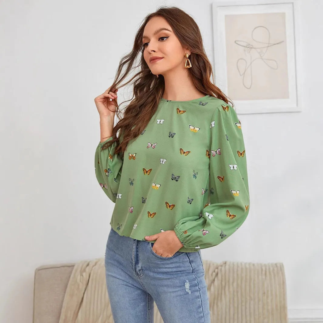Women's green loose-fit long sleeve shirt with a colourful butterfly print.