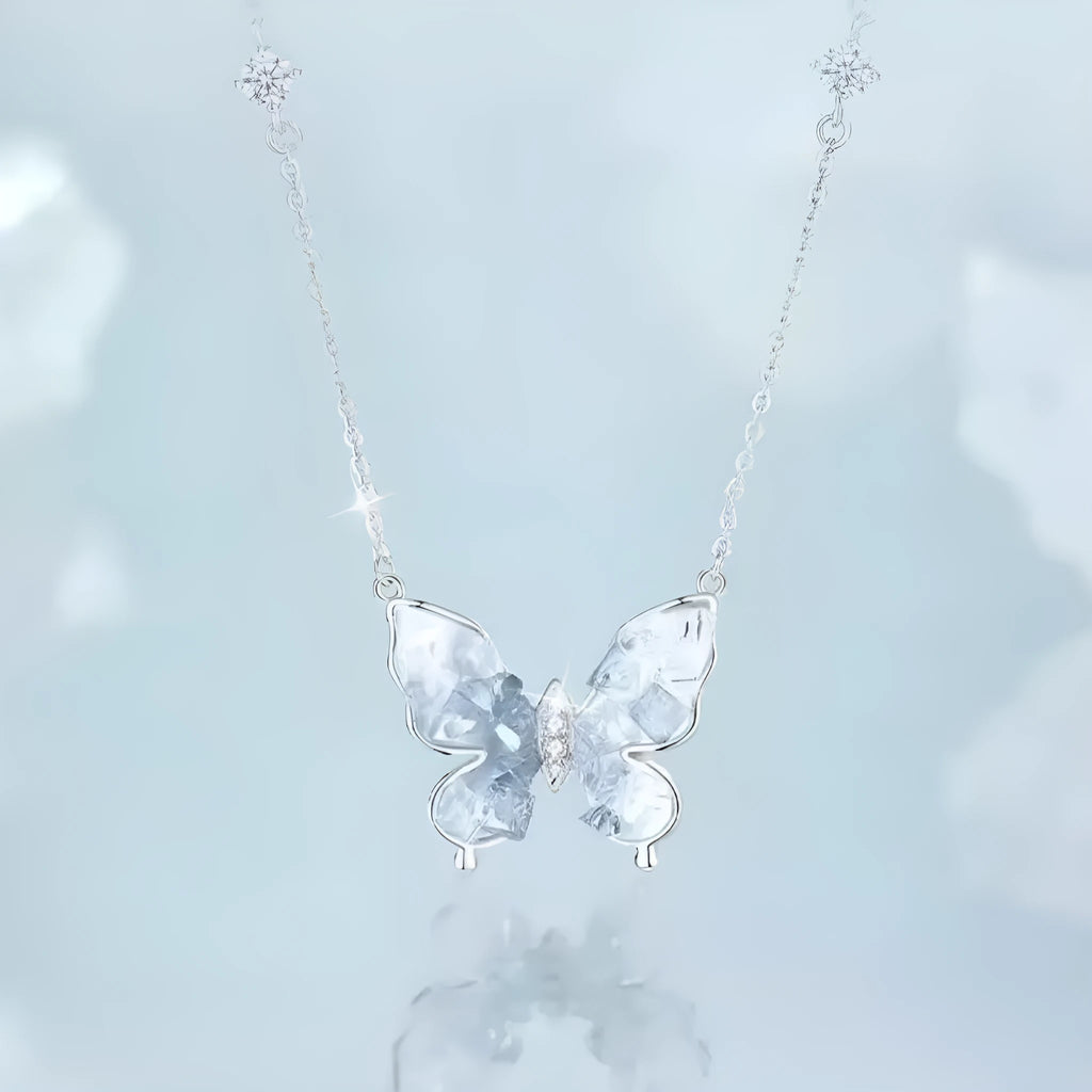 Close-up of a silver necklace with a detailed butterfly pendant on an O-ring chain.