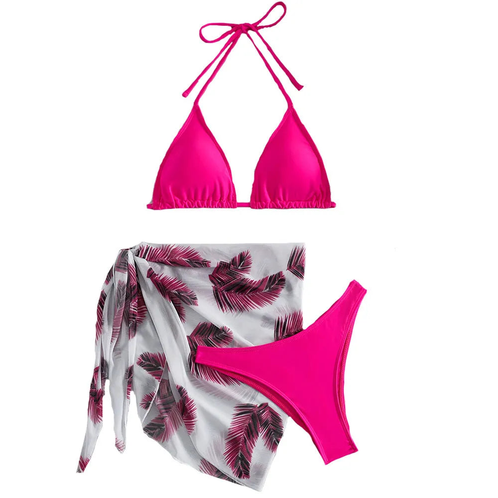 Orange three-piece bikini swimsuit set with a matching printed gauze skirt laid flat.
