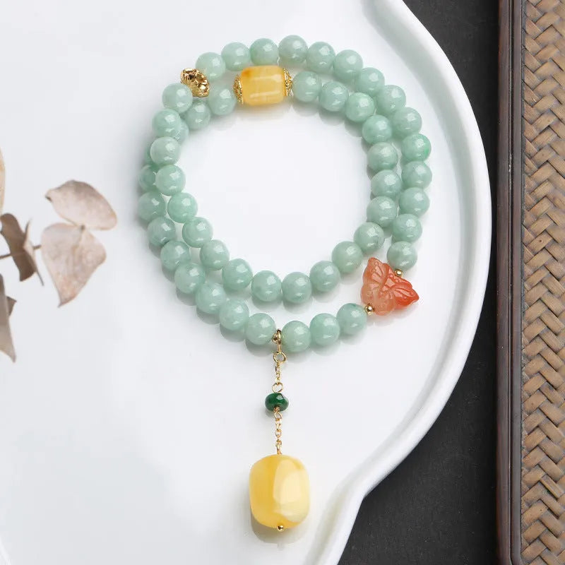Double-layer retro bracelet with emerald jade round beads and hanging beeswax barrel beads.