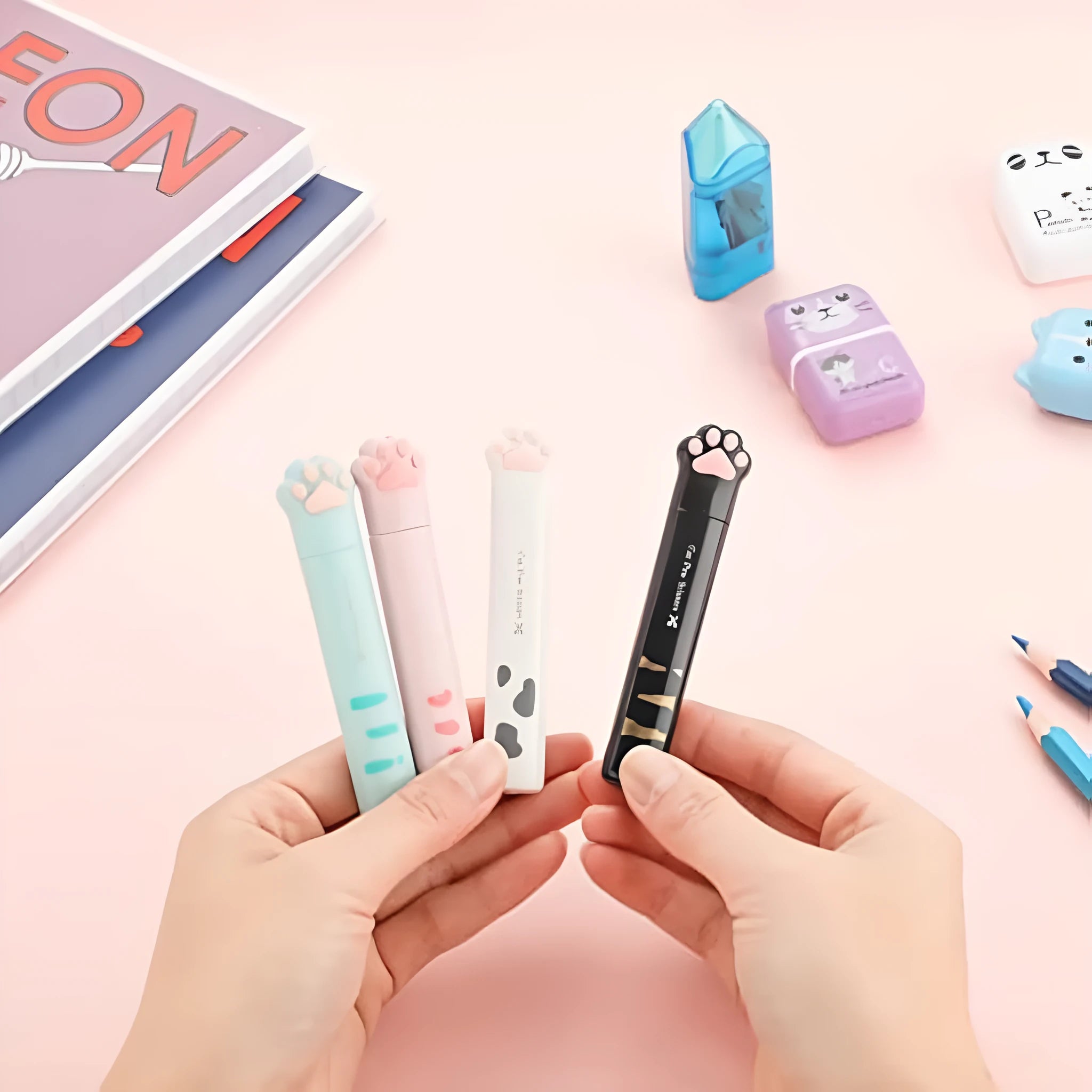 Cat paw design mini folding safety scissors in four colours: black, blue, pink, and white.