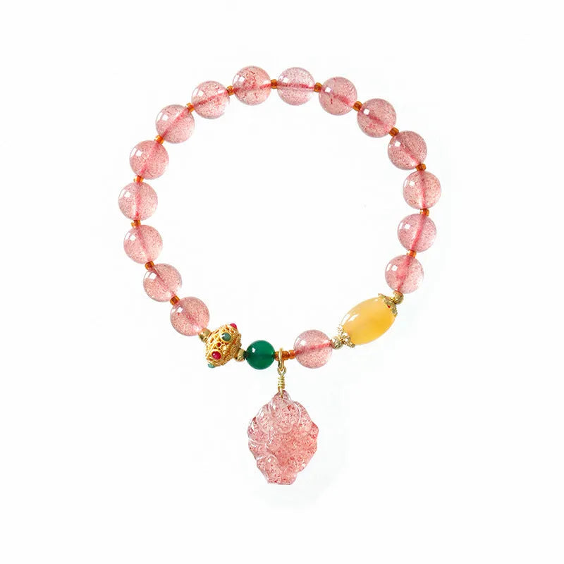 Women's Nine Tail Fox style strawberry quartz crystal beaded bracelet on wrist.