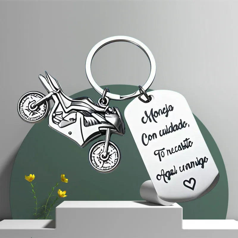 Stainless steel motorcycle-themed keychain with minimalist design, shown with its flannel storage bag.