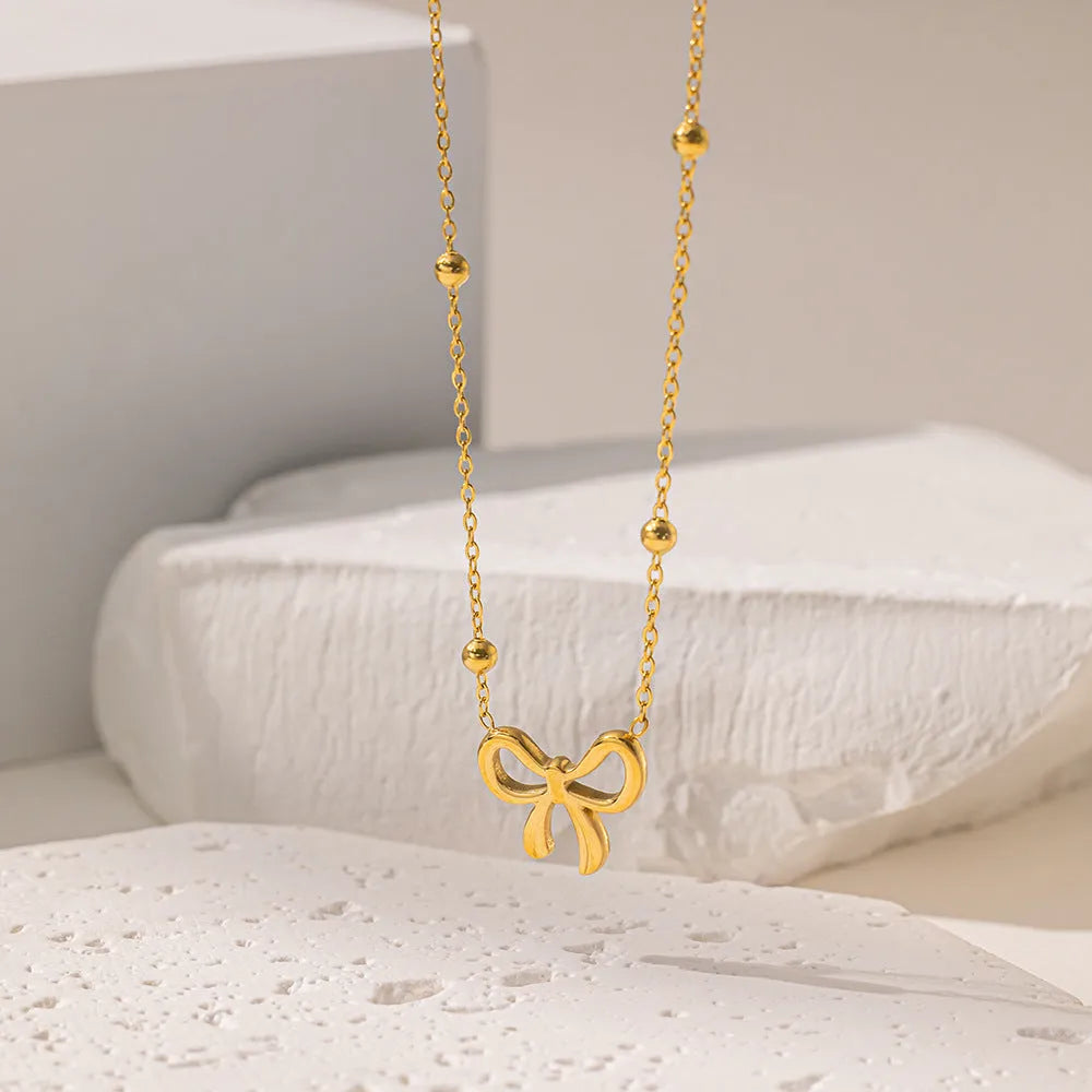 Gold electroplated bow necklace with adjustable 41-50cm length and cross chain