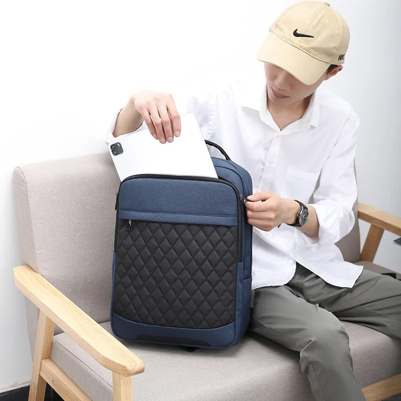 Men's solid colour Oxford cloth backpack with curved shoulder strap in black, blue, or grey.