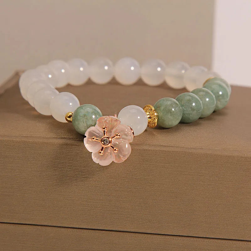 Emerald agate bracelet with white jade flower beads and pink accents on wrist