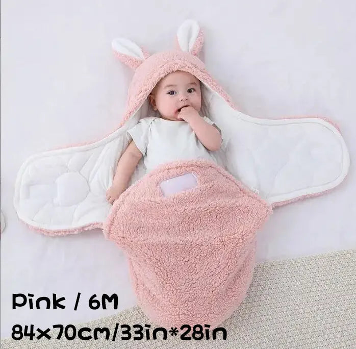 A baby wearing a soft grey fleece sleeping bag with hook-and-loop shoulder straps.