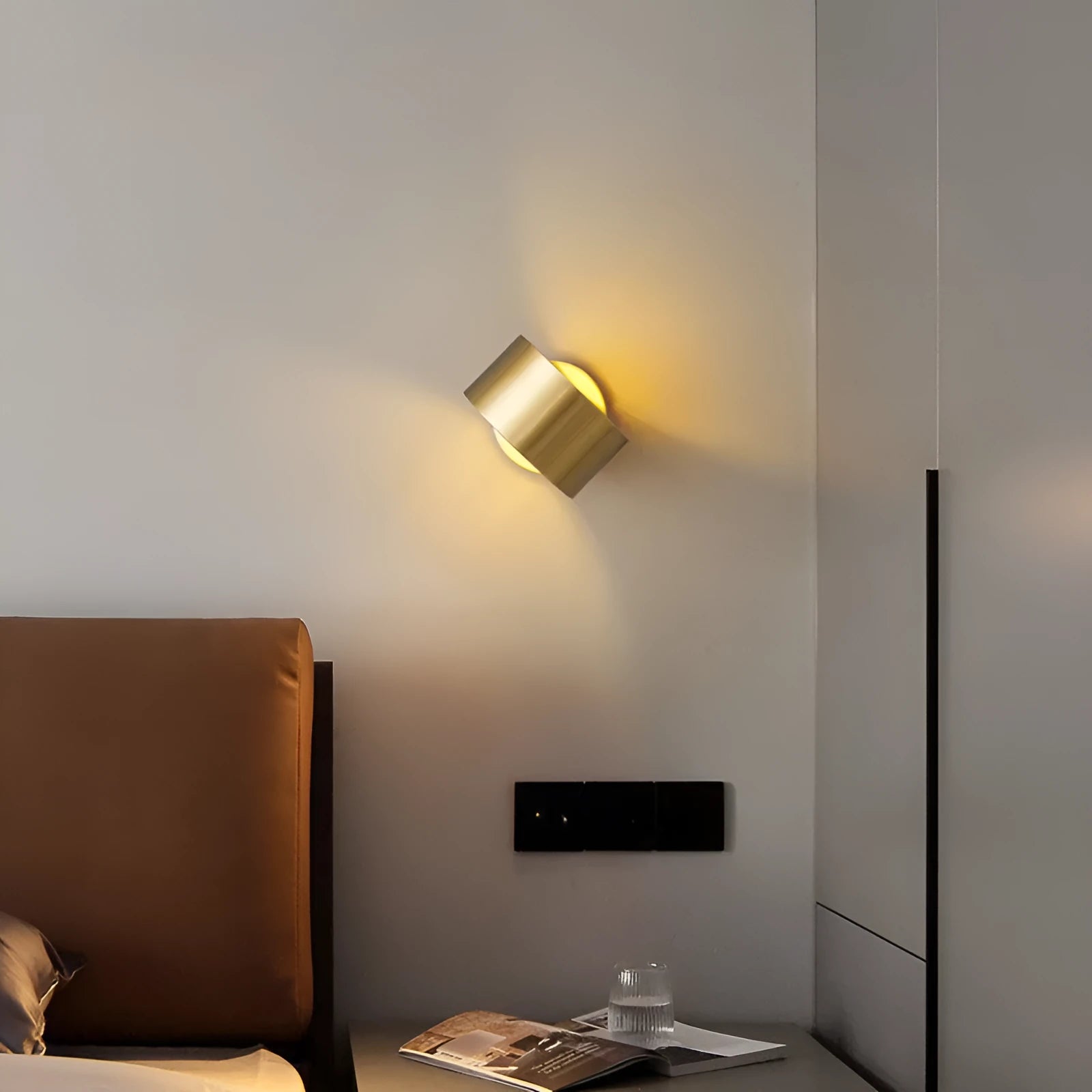 Modern minimalist copper wall lamp in black finish, mounted on a plain wall.