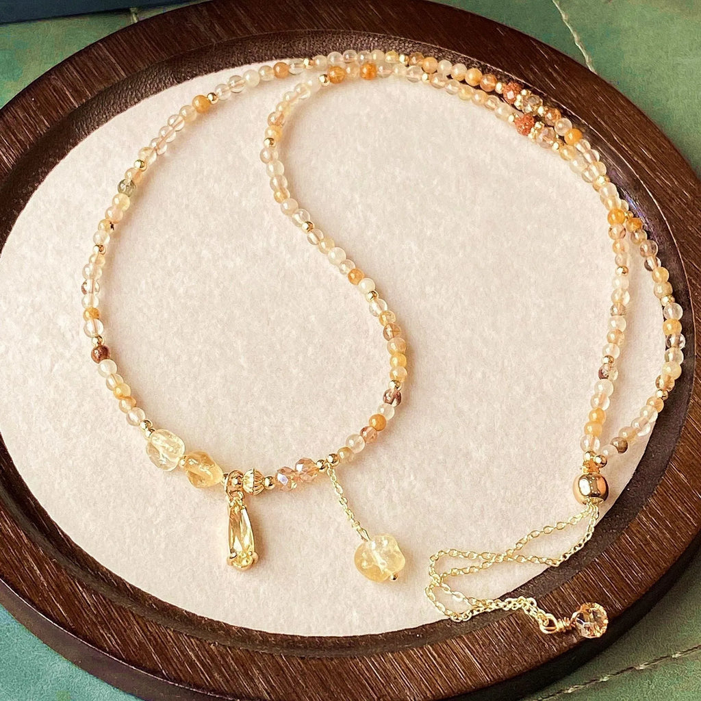 Women's three-circle citrine bracelet with caramel crystals and gold electroplated finish showing Saturn design detail