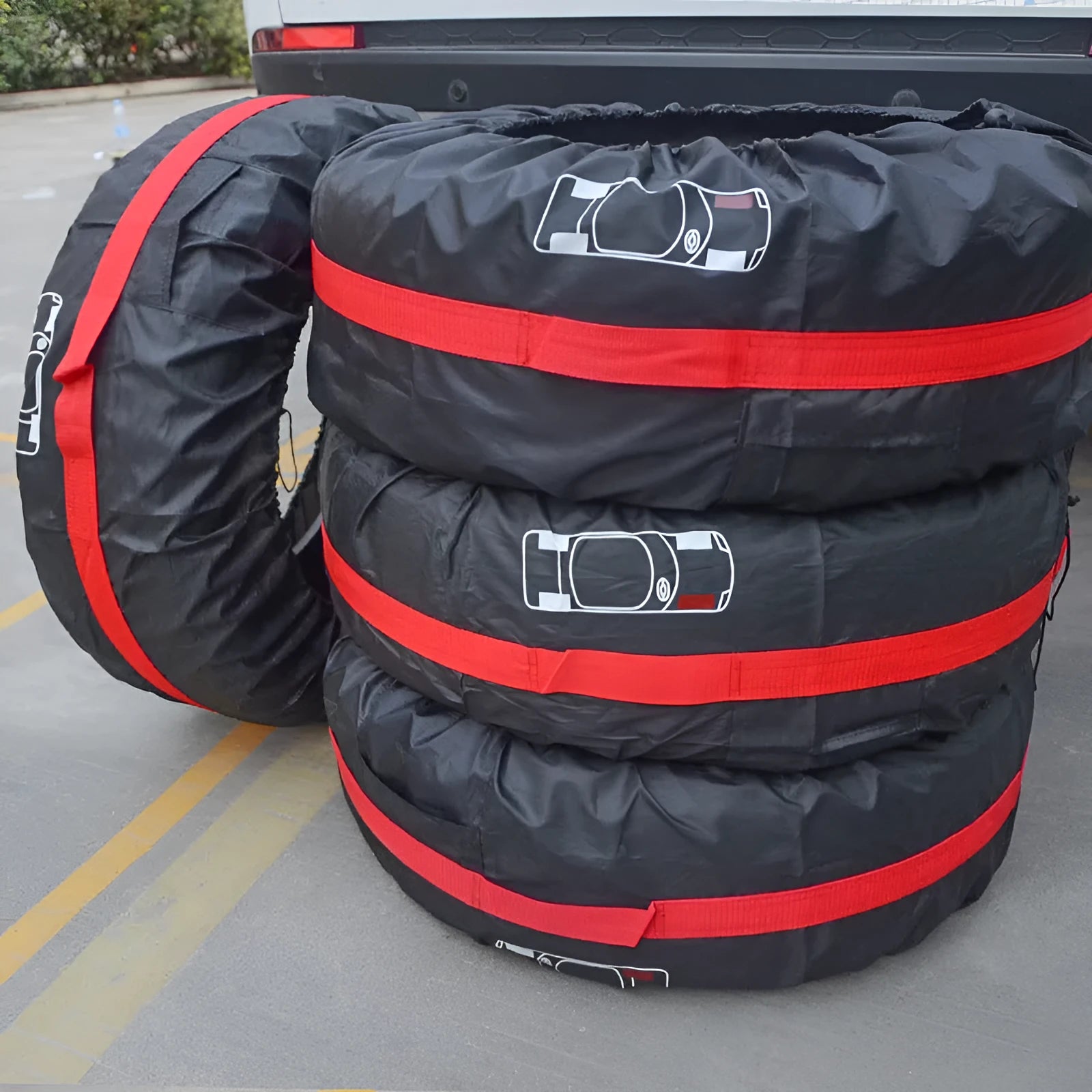 Set of four black polyester car tyre protective covers with a red belt style detail.