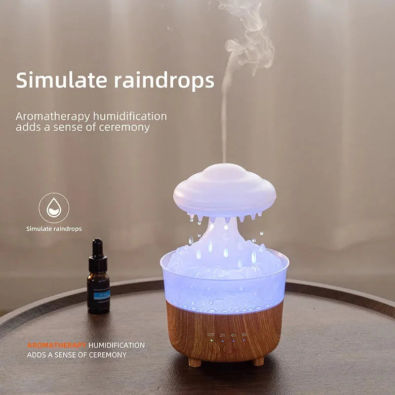 Wood grain white cloud-shaped humidifier diffuser with LED lights and water drop rain effect on a table.