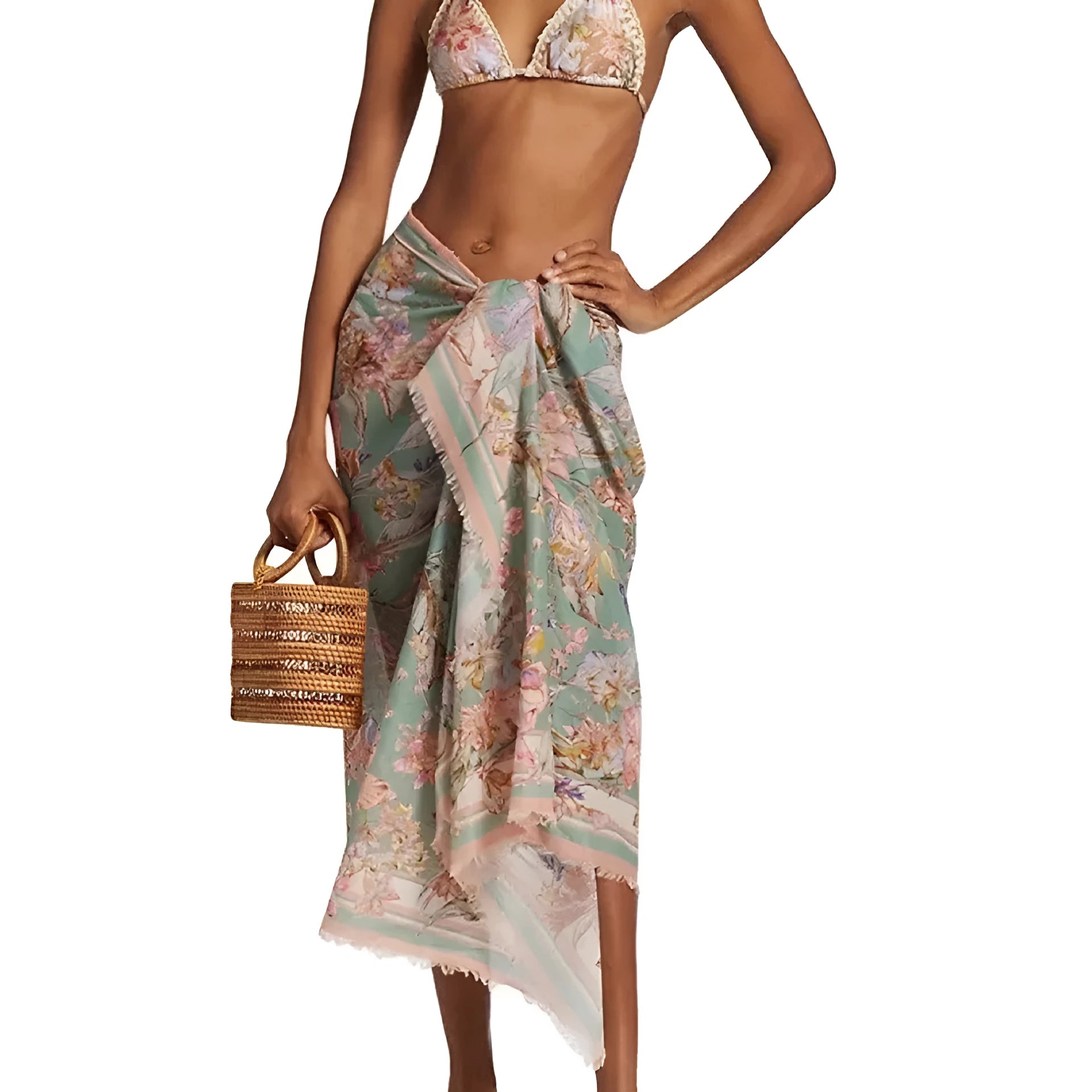 Women's creamy-white floral bikini swimsuit set with matching skirt on beach