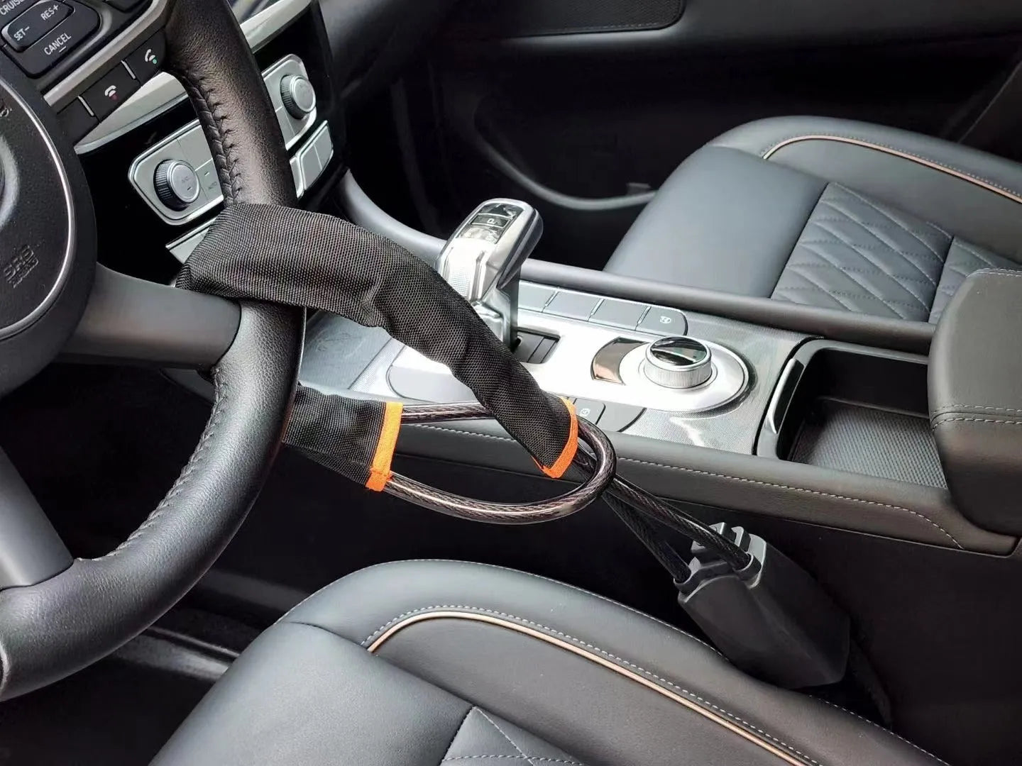 A red iron steering wheel lock with a copper core for General Motors cars, shown with its wire rope extended.