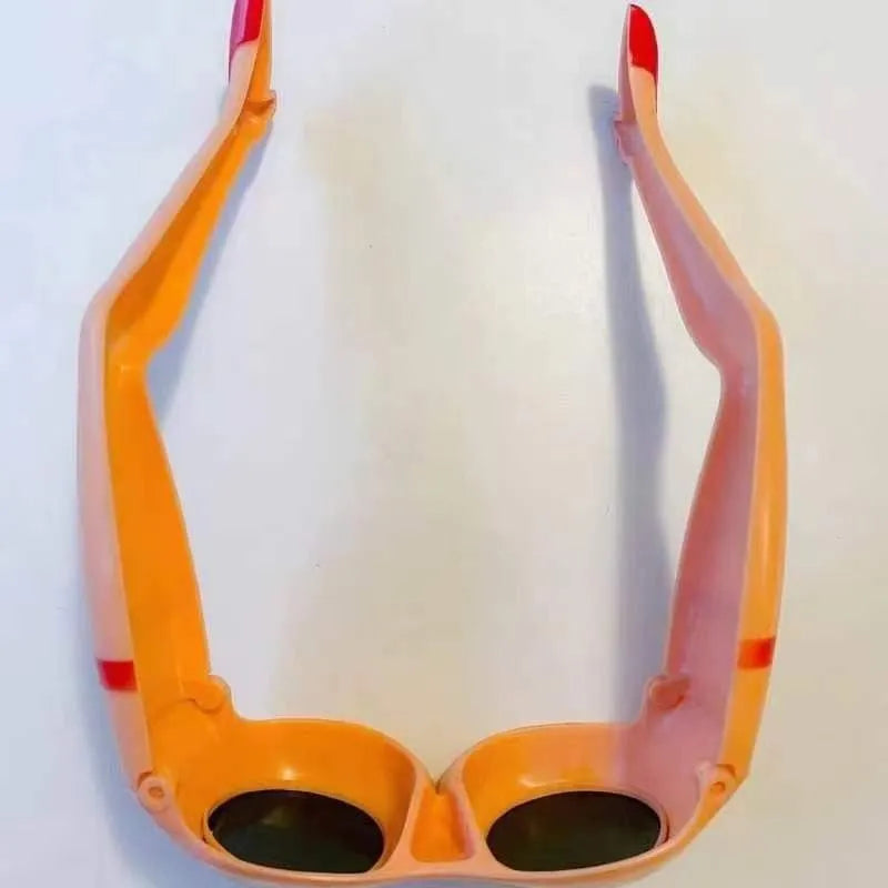 Orange plastic novelty sunglasses accessory for legs and hips on a white background.