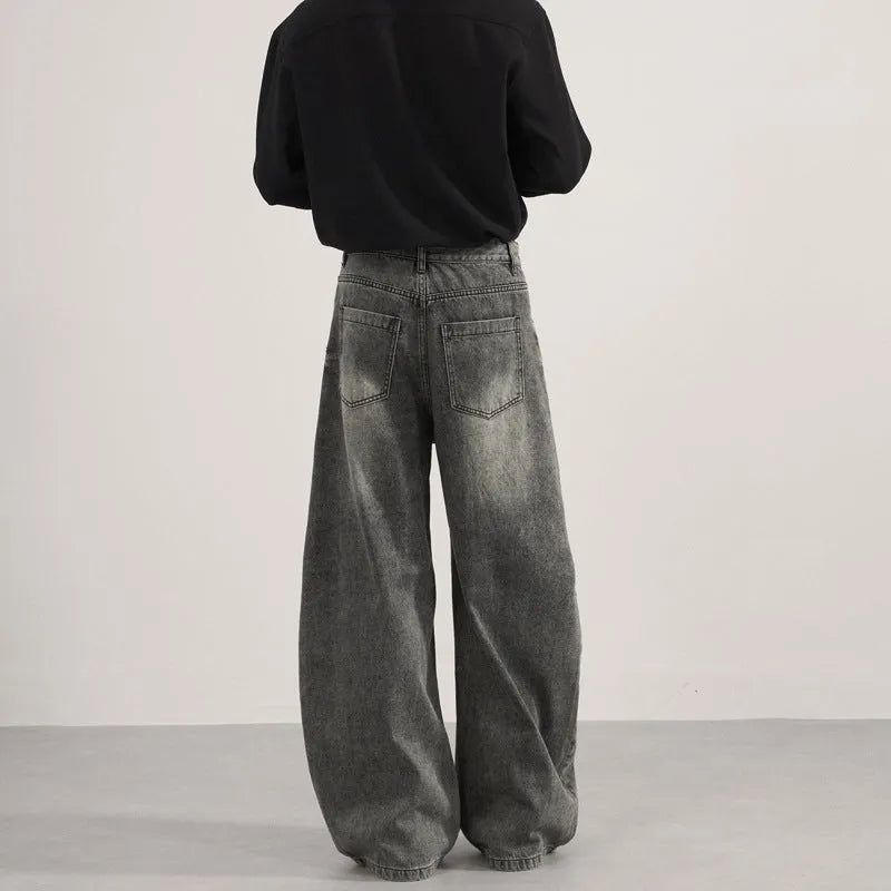 Men's loose straight washed denim jeans in black, front view showing zip fly and straight leg cut.