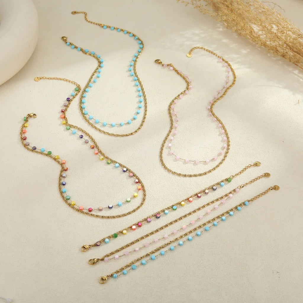 Gold-plated stainless steel double-layer necklace with colourful geometric beads on a white background