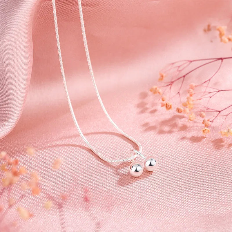 Silver cherry fruit pendant necklace on an adjustable snake bone chain for women.
