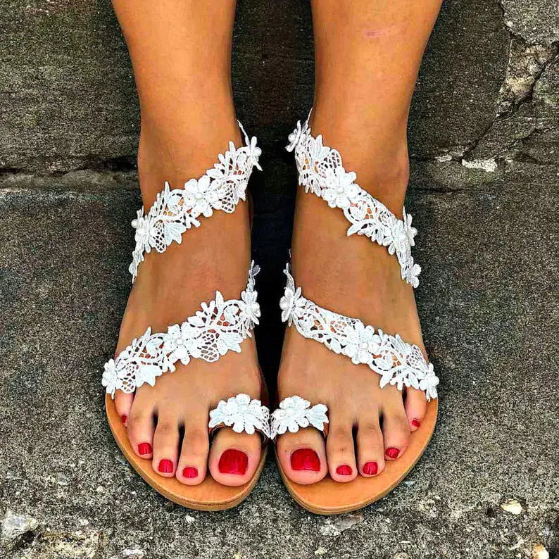 White women's flat sandals with floral patterns and rhinestones on a patent leather-look PU upper.