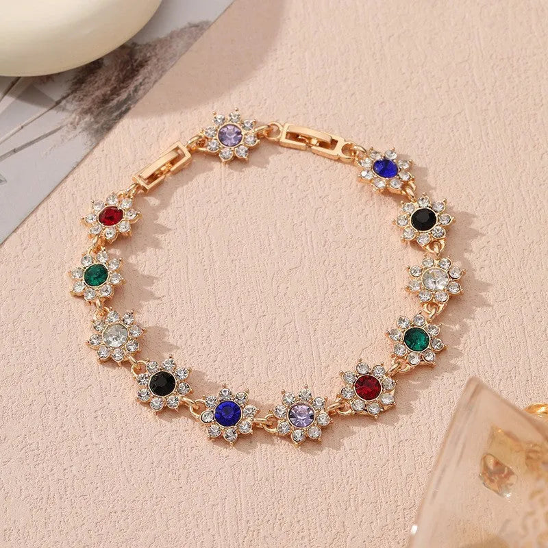 Women's floral charm bracelet in gold or silver electroplate with coloured gemstone effects.