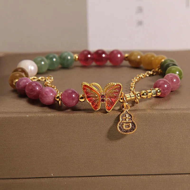Close-up of a women's agate bracelet with a tourmaline butterfly gourd pendant in natural jade colour.