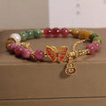 Close-up of a women's agate bracelet with a tourmaline butterfly gourd pendant in natural jade colour.