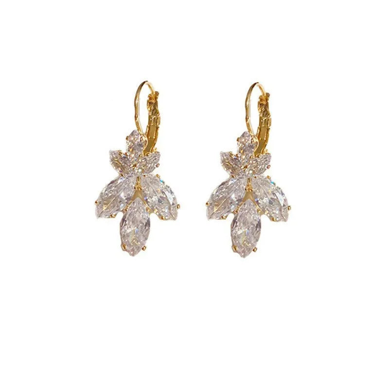 Platinum colour leaf-shaped earrings with inlaid zircon stones on white background