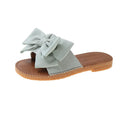 Women's beige slip-on sandals with a suede cloth upper, soft rubber sole, and decorative bow.