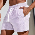 Man wearing loose grey mesh athletic shorts with elastic waistband for American football or summer sports.