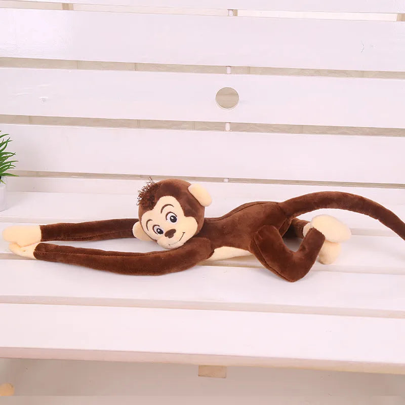 Long-armed pink plush monkey toy hanging from a curtain rod