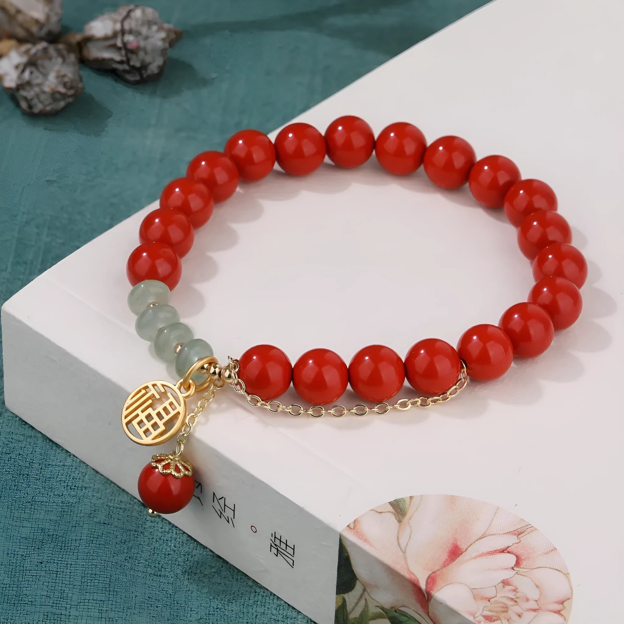 Retro women's bracelet with red sand cinnabar fu character pendant, jade spacer beads, and tassel detailing