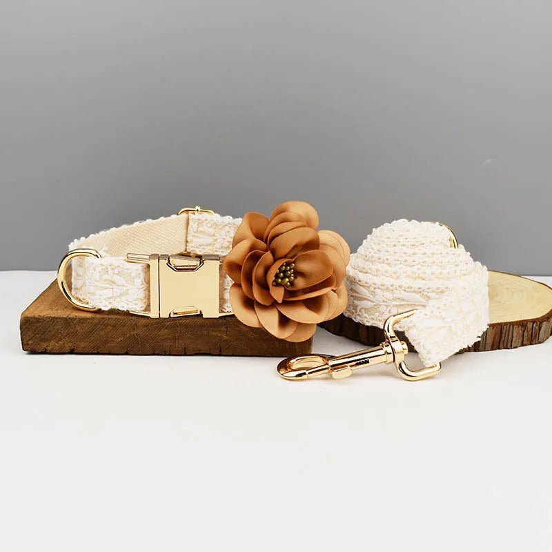 White lace-trimmed dog vest with matching collar, leash, and floral bandana on a small dog.