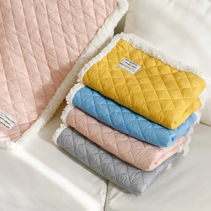 Quilted cloth pet blanket for cats in blue, shown on a cat bed, with size options M, L, and XL.