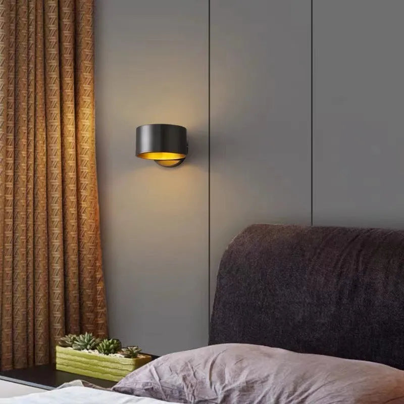 Modern minimalist copper wall lamp in black finish, mounted on a plain wall.