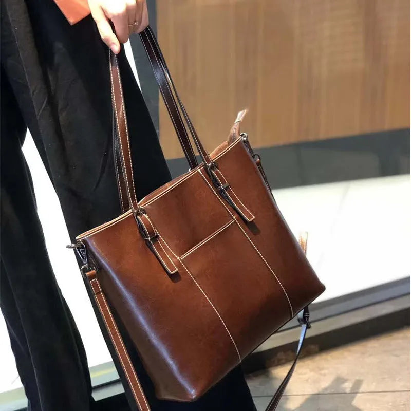 Brown genuine leather retro women's tote bag with multiple zipper pockets and three shoulder straps.