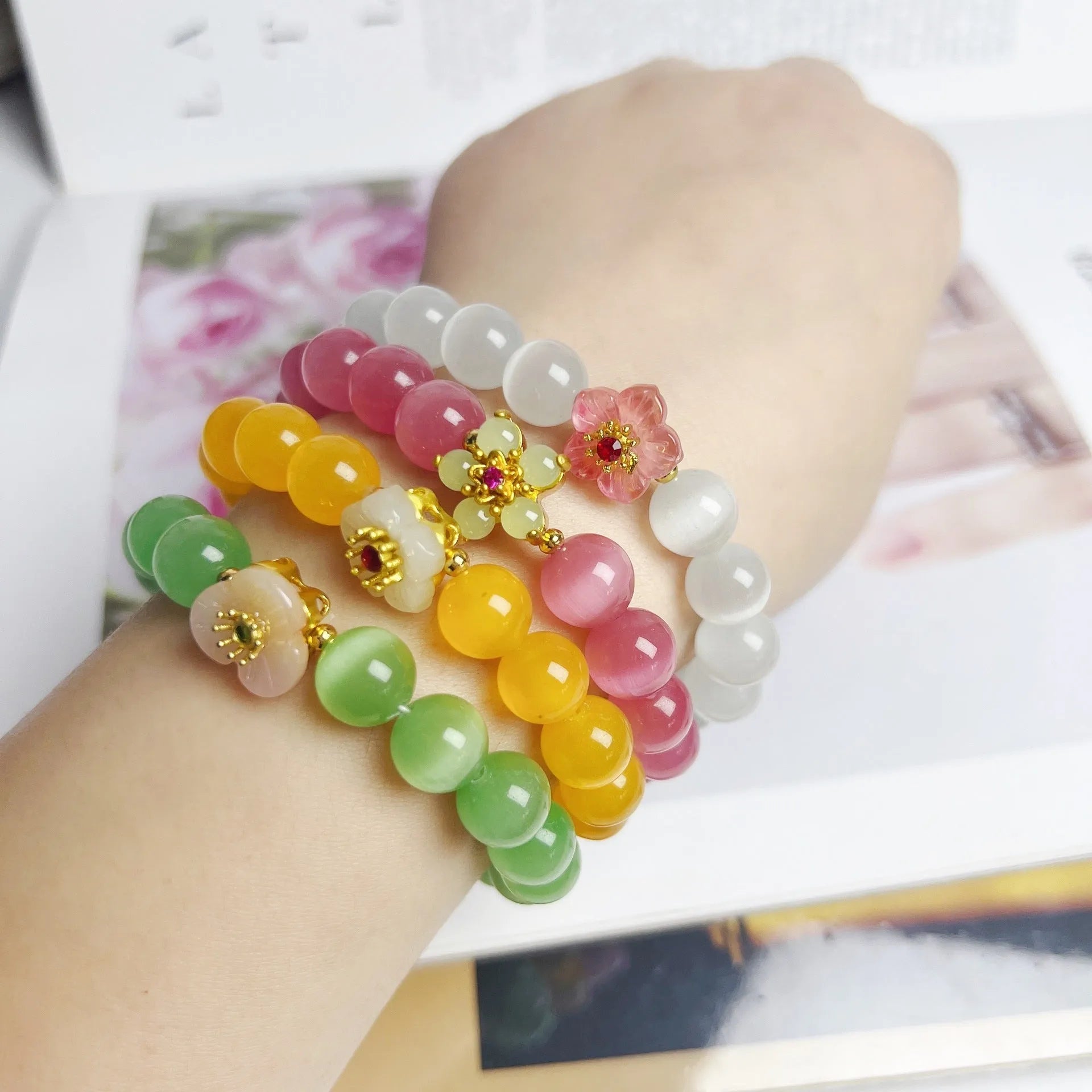 Handmade glass bead bracelet with floral design in yellow, pink, white, or green.
