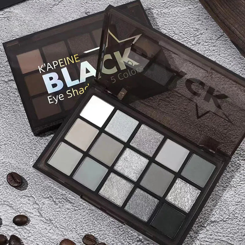 15-colour eyeshadow palette with matte and shimmer pans in grey, black, brown, and blue shades.