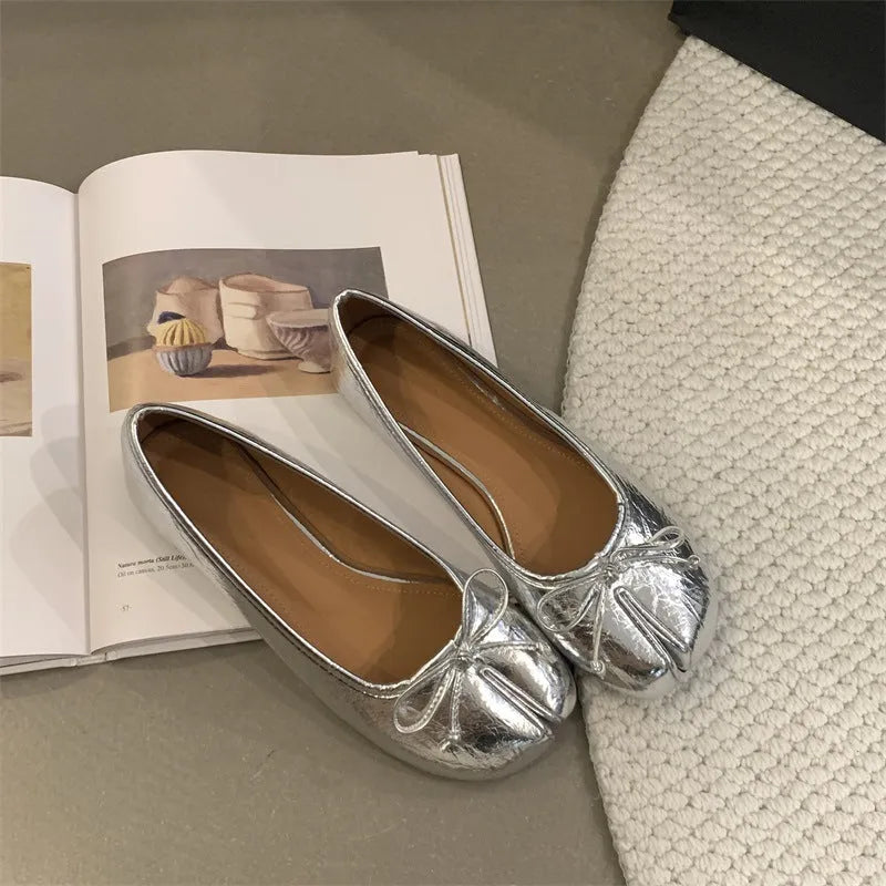 Women's flat pumps in beige with round toe and shallow-cut design on a rubber sole