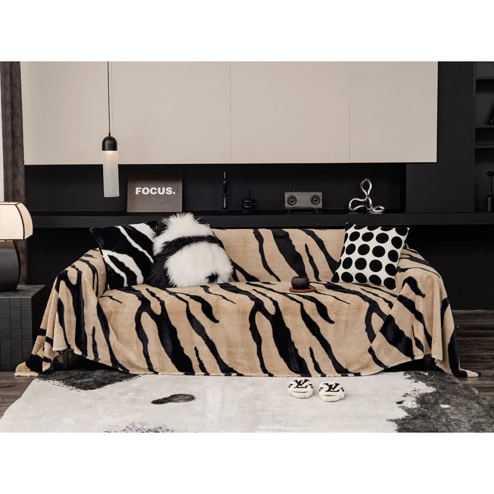 Zebra pattern flannel sofa cover draped over a sofa, showing non-slip underside and matching pillowcase.