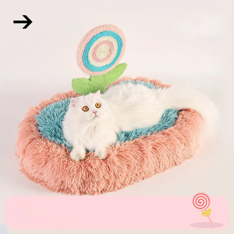 Pink elliptical plush cat bed with a removable, washable cover on a wooden floor.