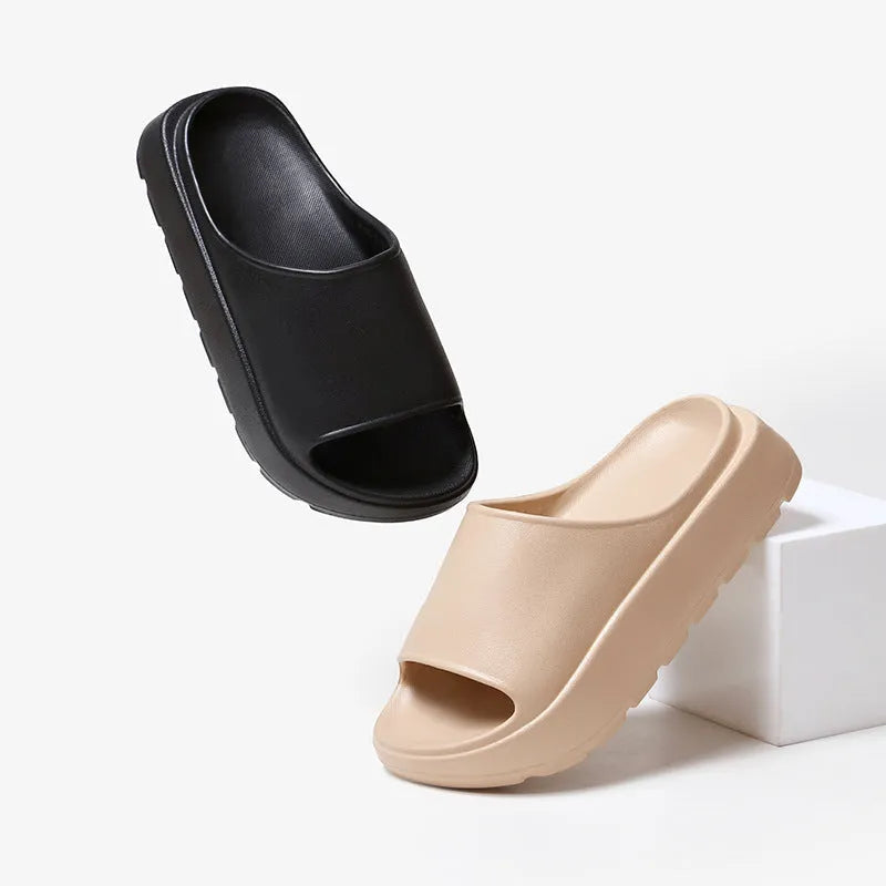 Women's beige fish mouth slippers with a thick 5.5cm EVA sole on a sandy beach.
