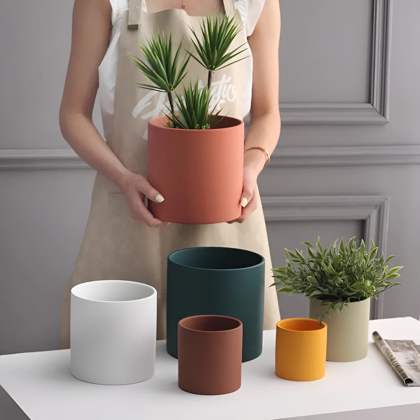 Colourful cylindrical ceramic succulent planter with drainage hole on a wooden surface