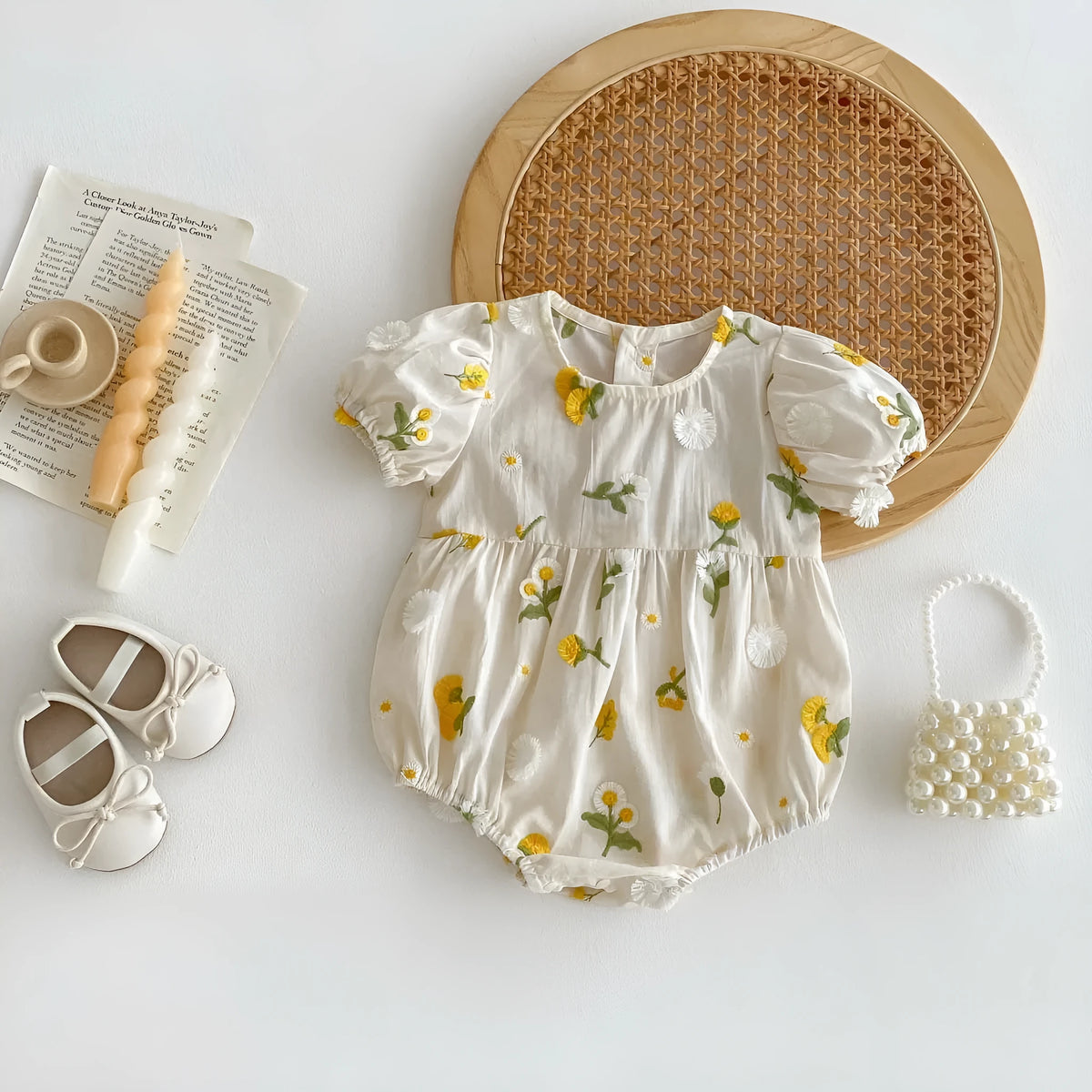 Apricot cotton baby romper with embroidered sunflower, short sleeves, triangle jumpsuit shape and hidden hook closure.