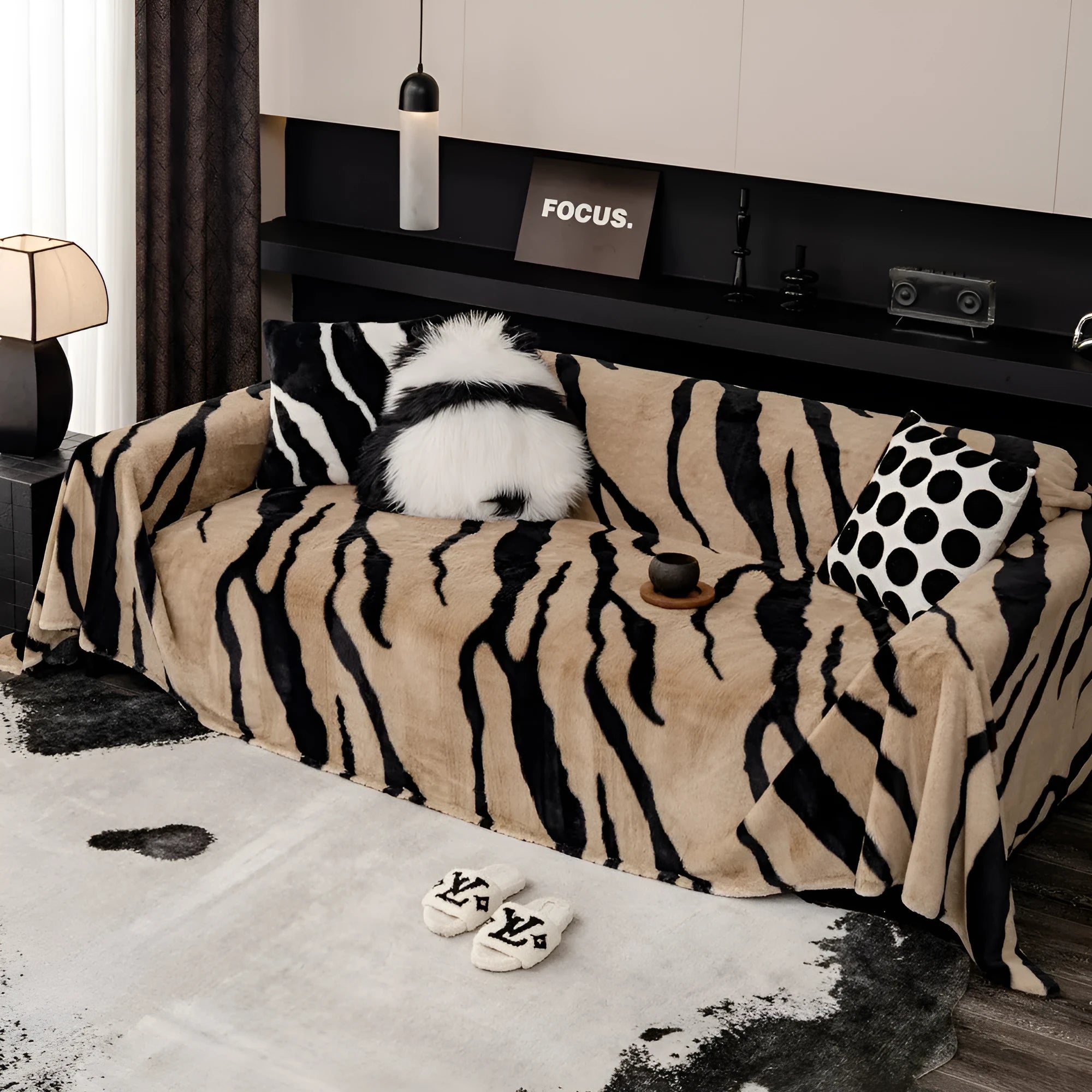 Zebra pattern flannel sofa cover draped over a sofa, showing non-slip underside and matching pillowcase.