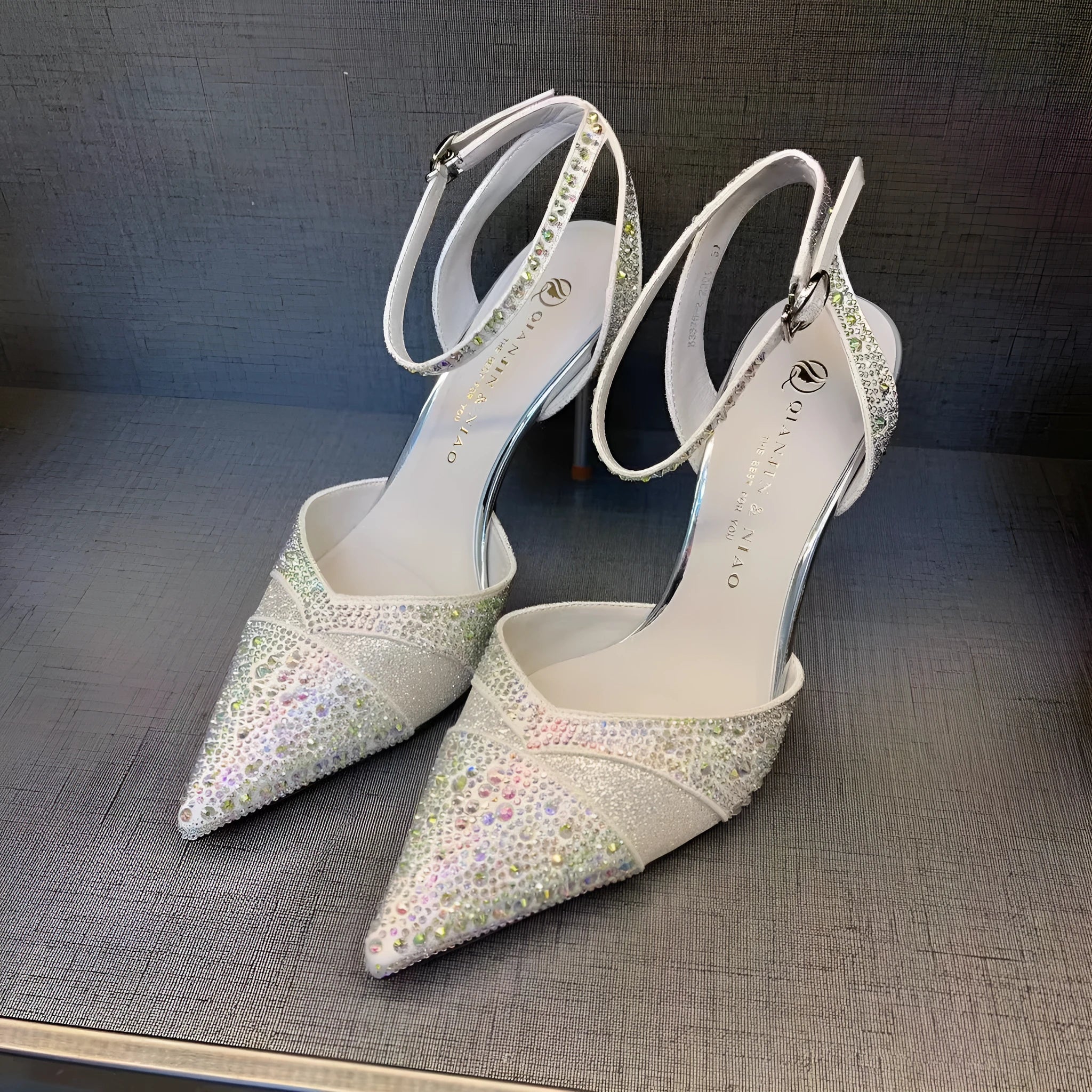 Women's black high heels with hollow design, red sole, and pointed toe on stiletto heel