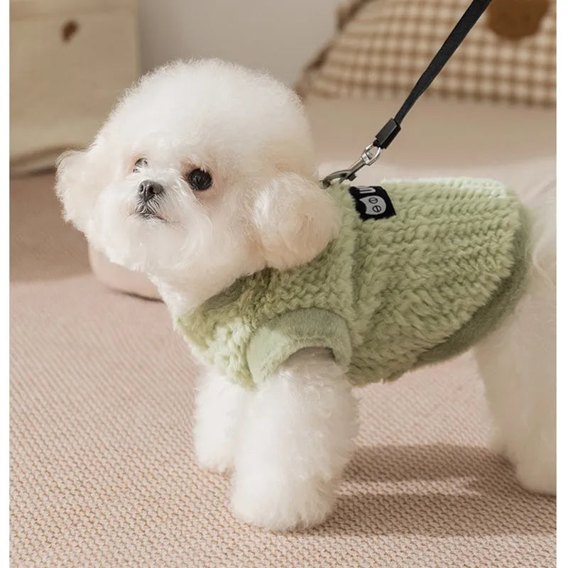 Two-legged sleeveless fleece dog vest with integrated leash ring in soft green or neutral beige, sizes XS to XL