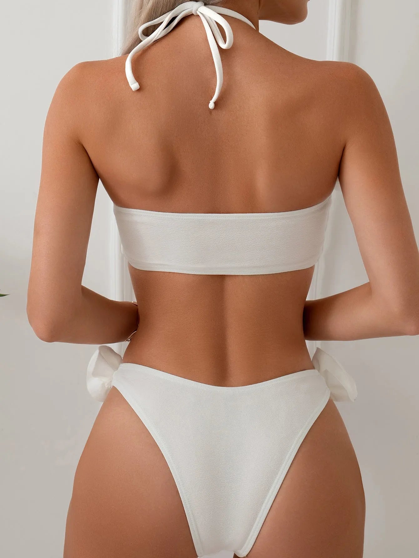 White halter neck lace-up bikini with split-cup design and three-dimensional floral details