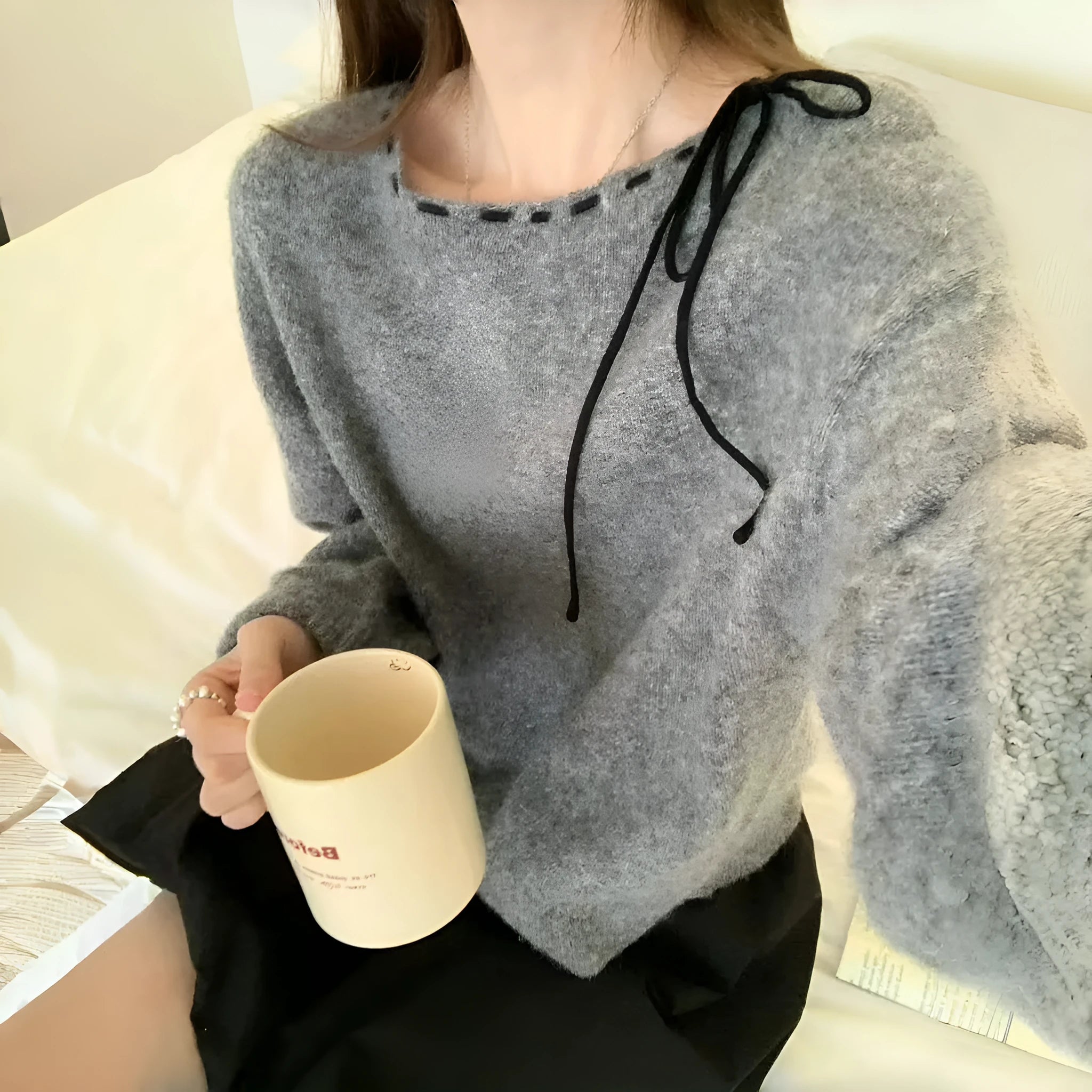 Grey loose-fitting women's knitwear pullover on a hanger.